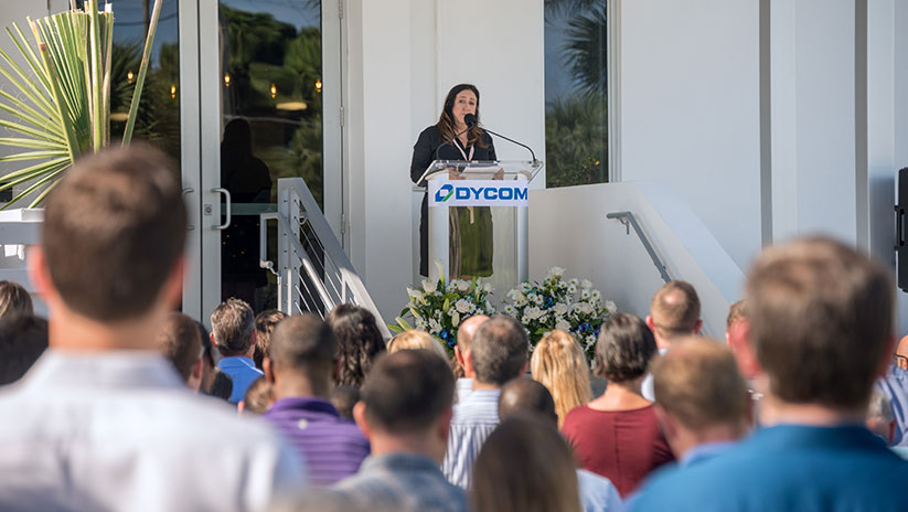 More than 200 employees gather outdoors to celebrate the ribbon-cutting event.